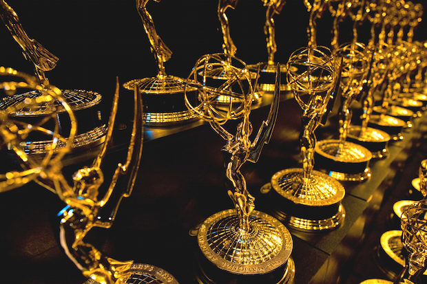 Dozens of Emmy Awards on a shelf
