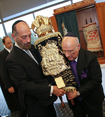 Cantor Joseph Malovany and Ira A. Lipman, donor of the Torah scrool, carry the dressed scroll