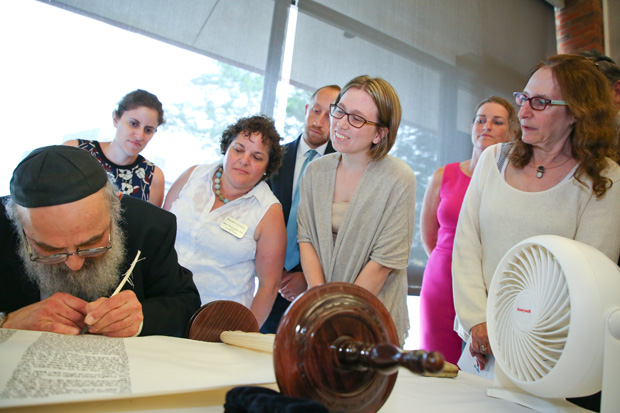 Brandeis staff watch Rabbi Binyomin Spiro inscribe the Torah scroll