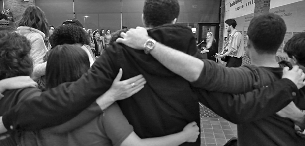 Attendees of the vigil put arms around each other.