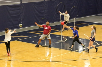 The Brandeis Quidditch team practices in Gosman. There are three vertical hoops and players hold sticks for brooms 