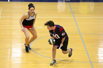 Two members of the Brandeis Quidditch team practice in Gosman. Players hold sticks for brooms 