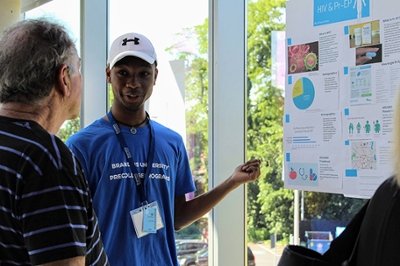 student speaking to visitor about poster