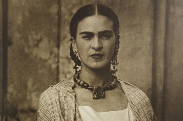 Sepia-tinted portrait of Frida Khalo, wearing large earings and a large necklace