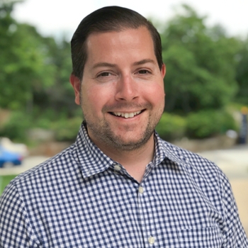 Staff member Eric Dunn in a white and blue gingham shirt