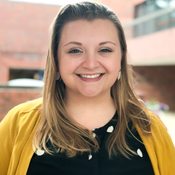 Kaitlyn Rogers, accessibility specialist and chair of the Brandeis Pride Alliance, in a yellow sweater