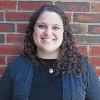Katy McLaughlin, academic services, standing in front of a brick wall