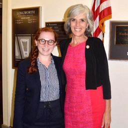 Sage Rosenthal'19 stands with U.S. Rep. Catherine Clark in front of a U.S. flag