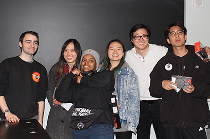 group of students stand in front of a blackboard