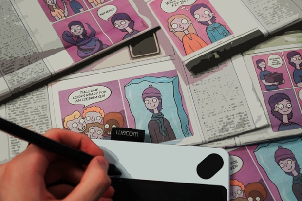 A hand writing on a tablet with a stylus on top of newspaper comics by Vicente Cayuela '22