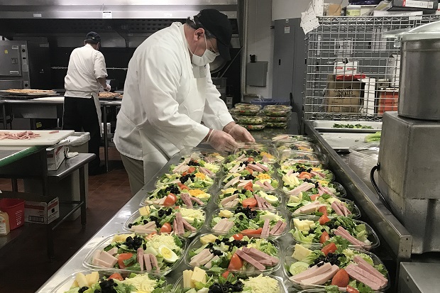 a chef filling plastic salad bowls