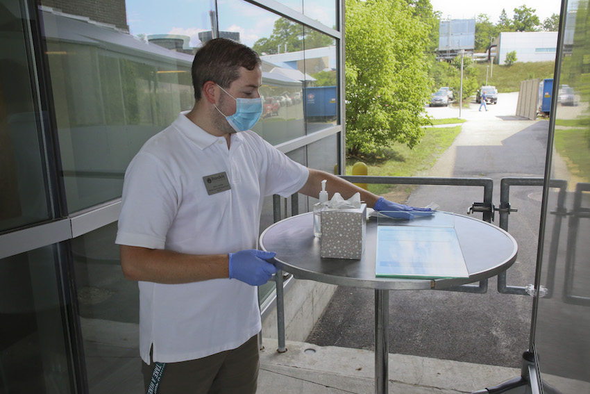 A person wipes down a testing table