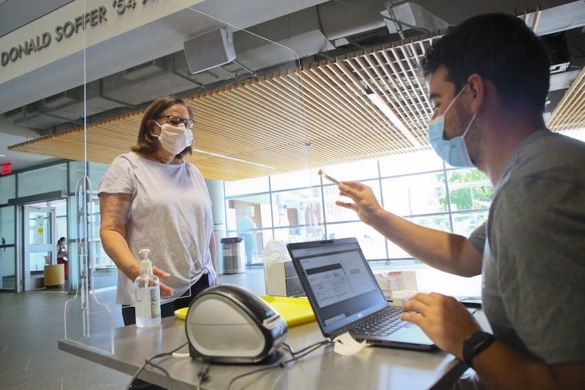 A staff person hands a person a test tube