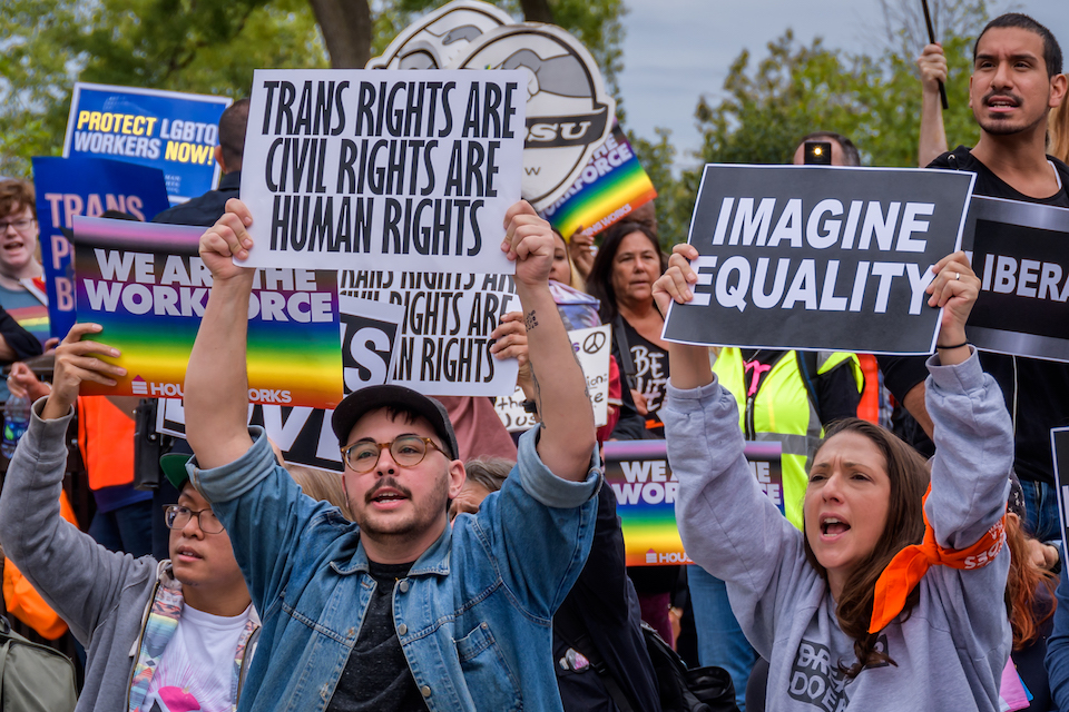 Trans rights protesters hold signs