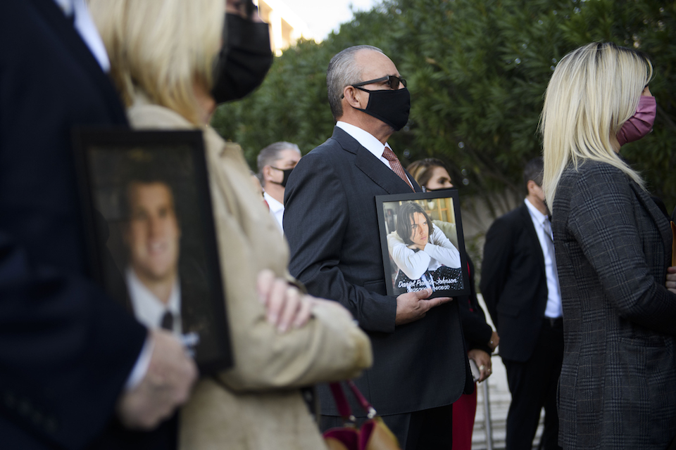 Jaime Puerta (C), holds a portrait of his son Daniel Puerta-Johnson, who died in April 2020 at the age of 16 from a pill containing fentanyl