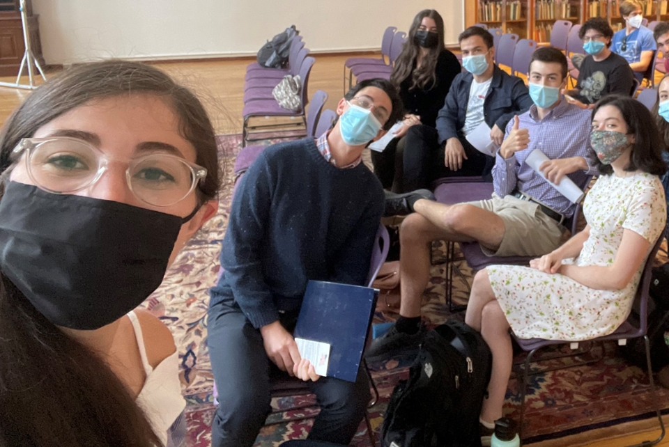 Students in masks sitting on purple chairs 