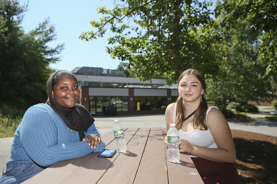 Two students seated at a picnic table