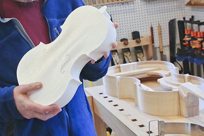 Harry Mairson holds a 3D printed model of a viola