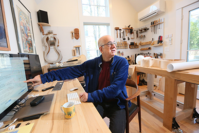 Harry Mairson points to his computer in his workshop