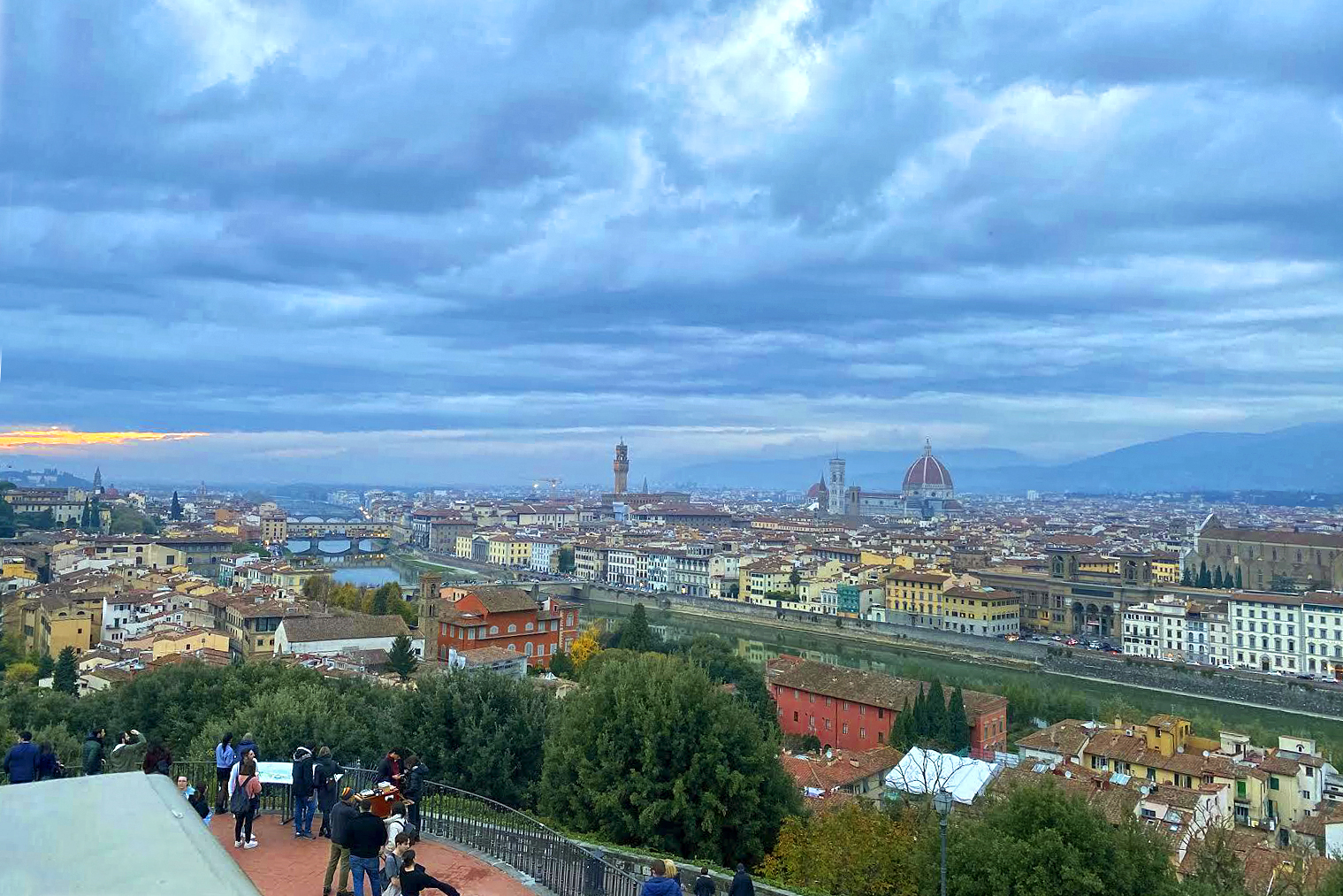 The Florence skyline under a dramatic cloud-filled sky
