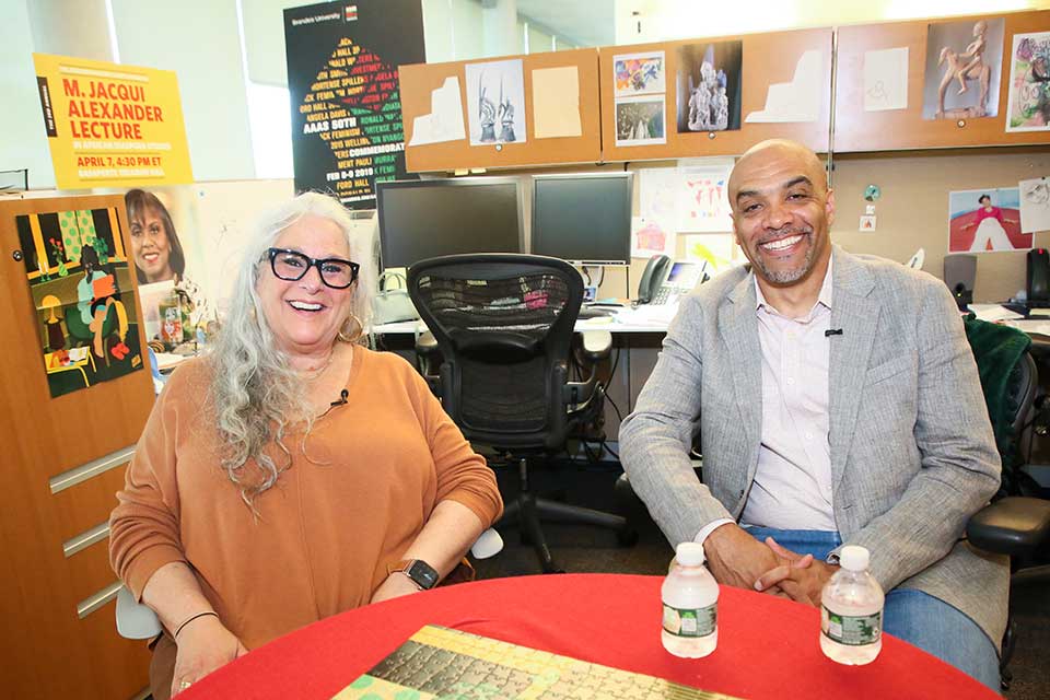 Marta Kauffman and Professor Chad Williams sit in an office