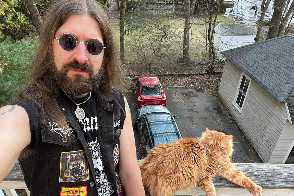 Jeremy Swist poses with his fluffy long haired cat
