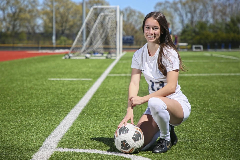 Juliette Carreiro poses with a soccer ball on the field
