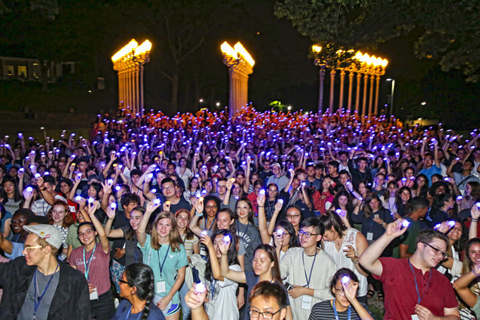 Students pose in front of the Light of Reason with flashlights