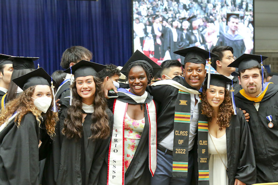 A group of students smile and pose for a photo at commencement 2022.