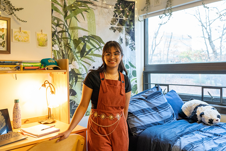 Rubaiya stands in her room among her unique decor.