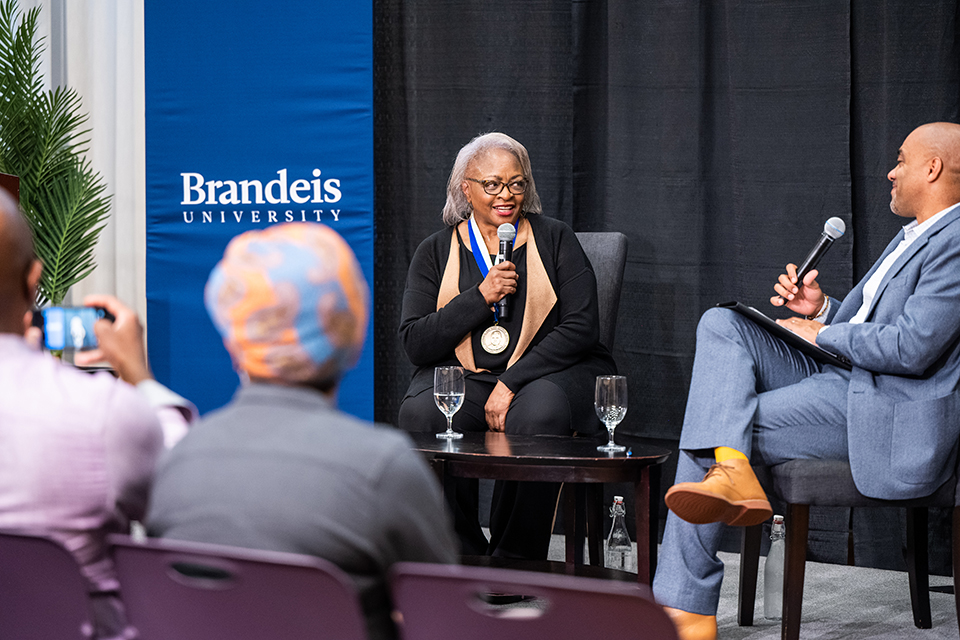 Carol Anderson, seated on the left, speaks into a micrphone while looking at Professor Chad Williams, also seated with a microphone