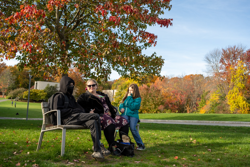 campus foliage and people on a bench