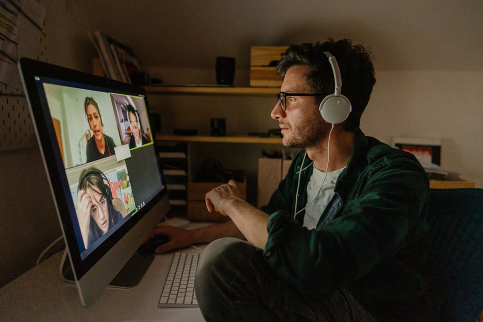 Person working from home at desktop on a zoom video meeting.