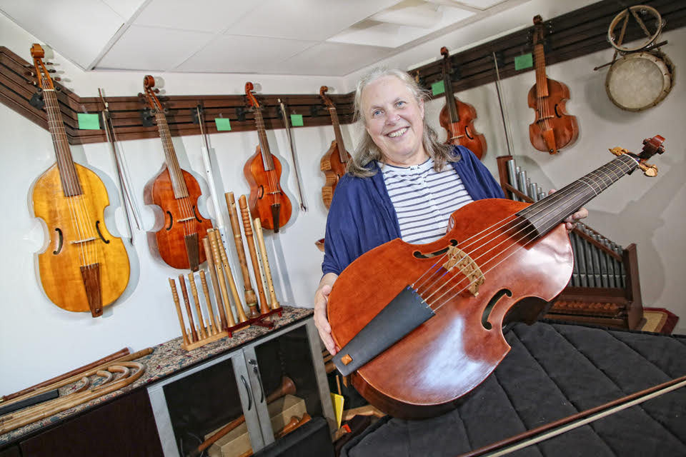 Sarah Mead in the instrument closet, holding her viola da gamba