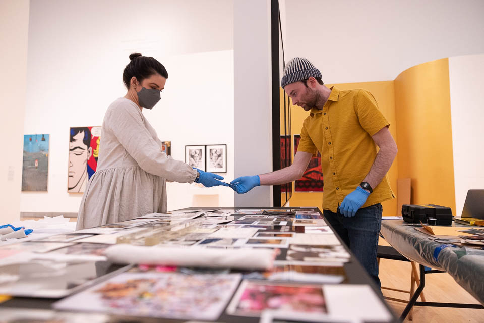 Two people laying out art