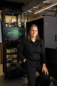 Christine Grienberger stands in front of a video screen in a darkened room