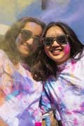 Smiling brandeis students covered in paint during the Indian celebration of Holi