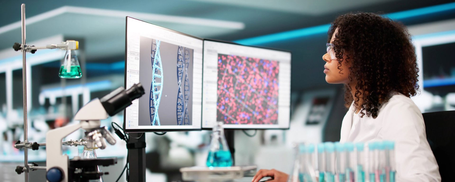 Woman in lab looking at computer screens