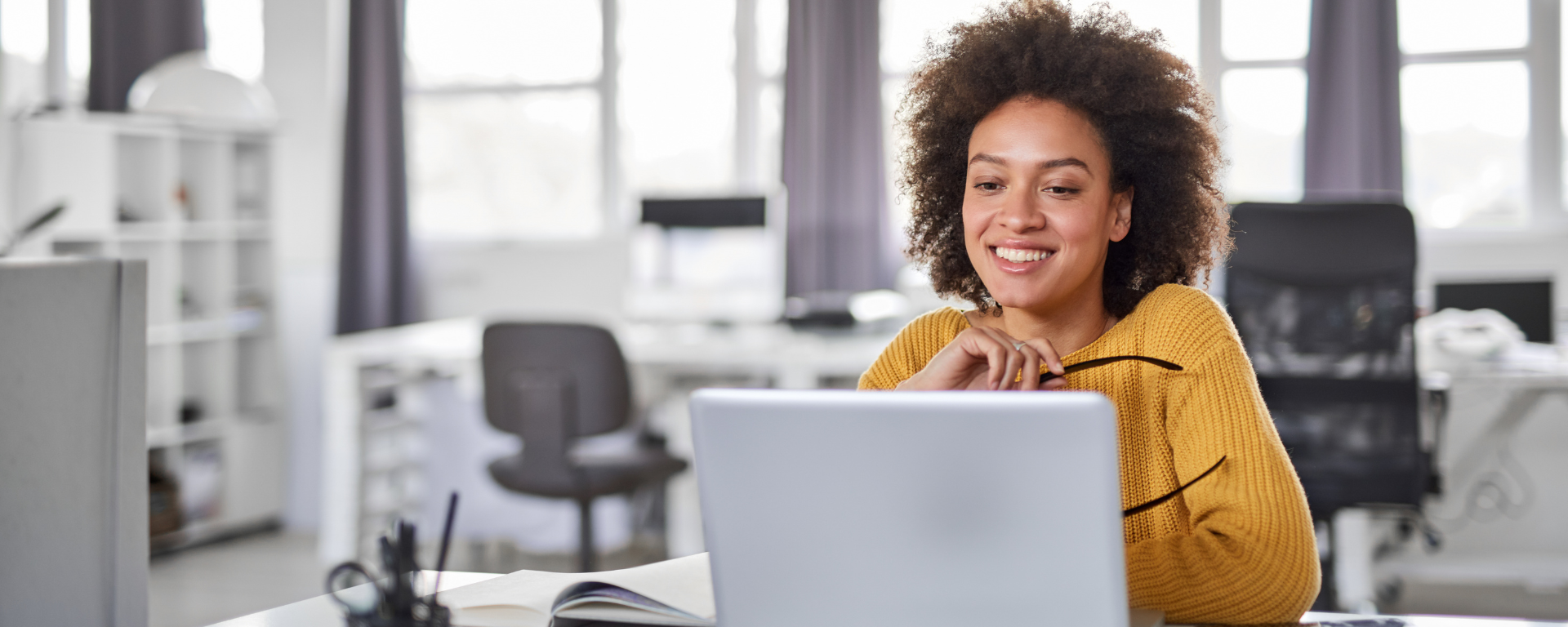 Woman smiles while working on computer.