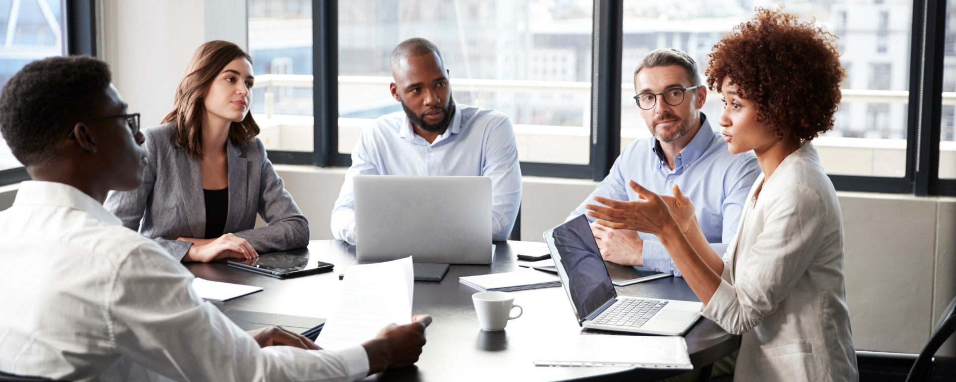 Professionals sitting around a board table.