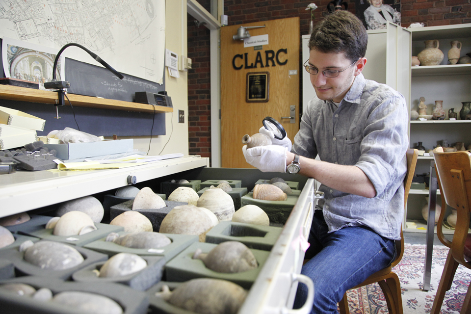 student looking at ancient pottery