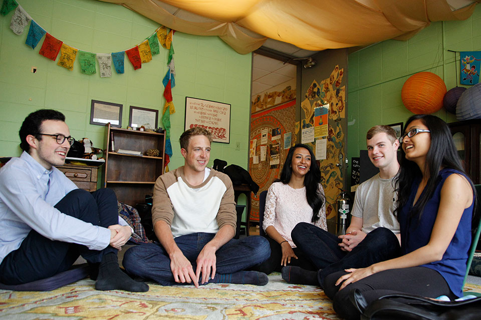 A group of 5 students sits on the floor in the Peace Room