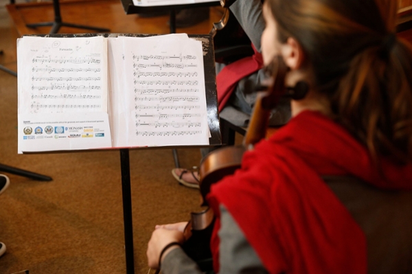 Looking over the shoulder of someone playing violin looking at sheet music