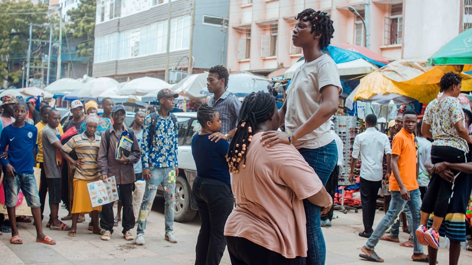 people lifting other people with the passers-by on the street watching