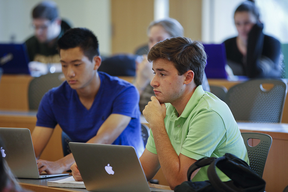 two male students on computers in classroom