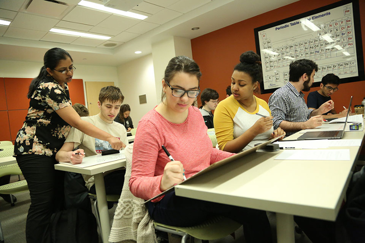 Arpana Baskaran assisting a student in a classroom