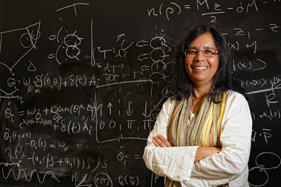 Babul Chakraborty in front of a chalkboard covered with mathematical equations