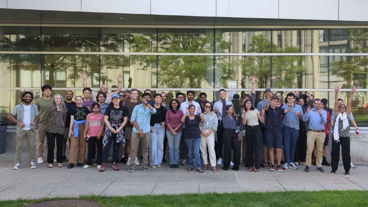 physics faculty and students standing outside in front of Shapiro Science Center