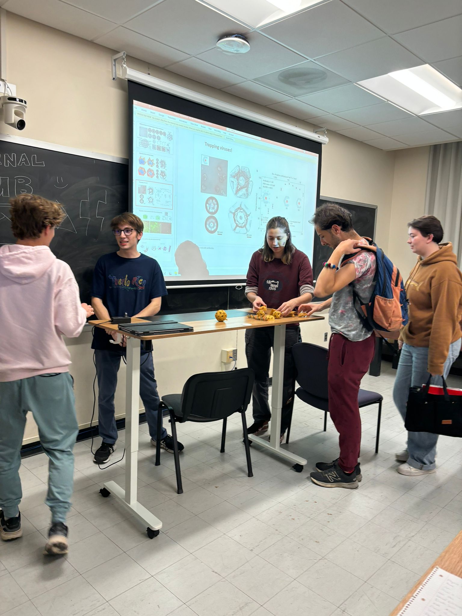 Students gathered around a presentation during a physics club meeting.