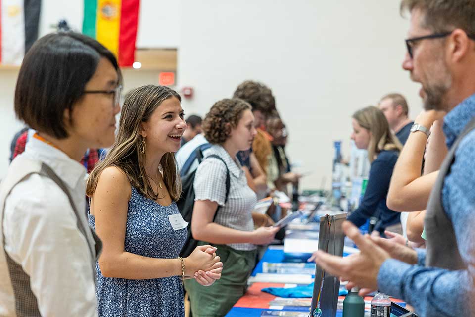 Students and study abroad representatives talking at a fair.